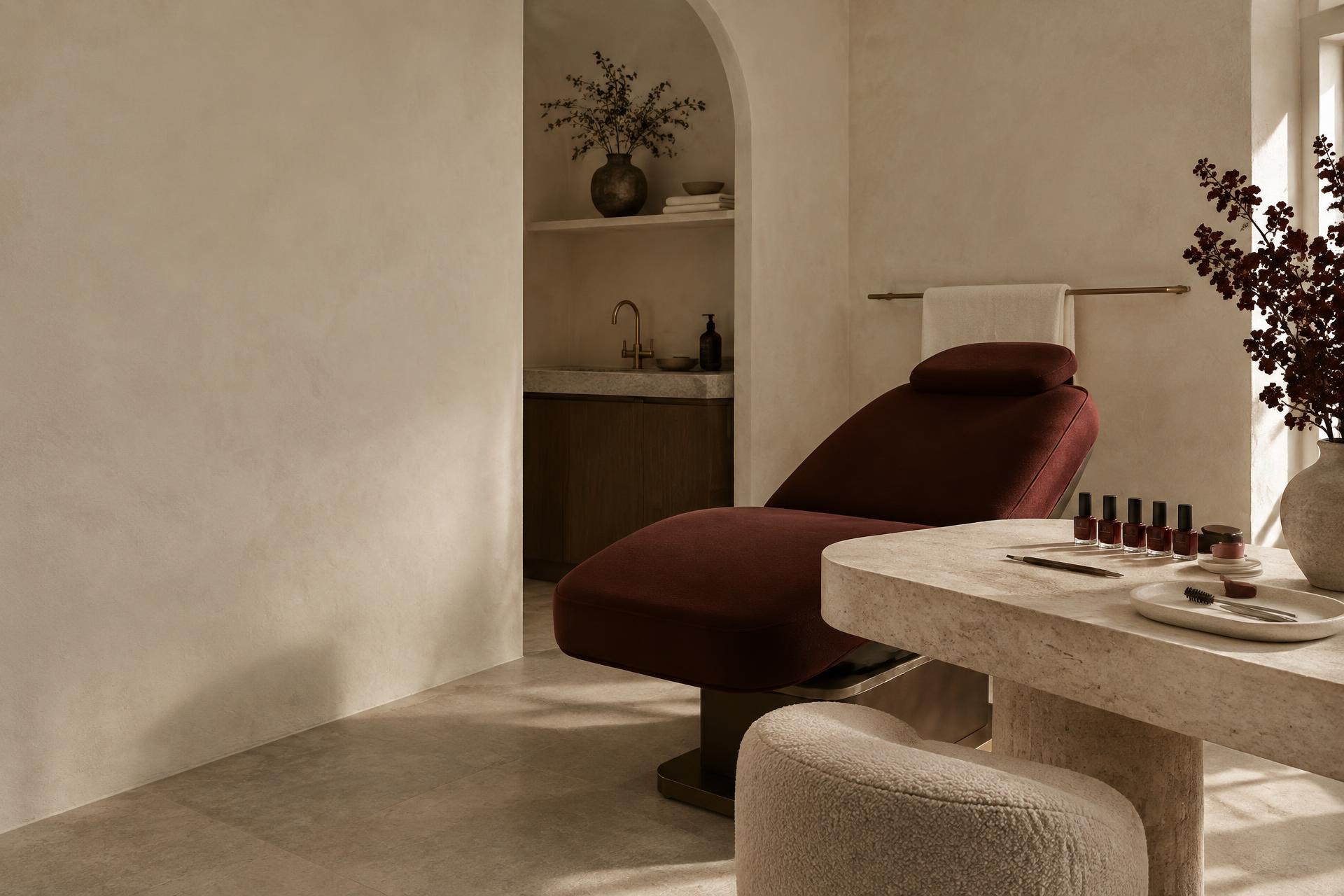 The SOLÈNE STUDIO room: an oxblood treatment chair, a manicure trolley and ivory plaster walls